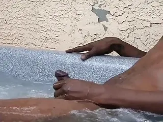 Black amateur solo strokes cock in an outdoor jacuzzi